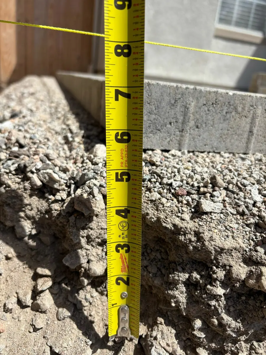 Evidence photo: a tape measure in the excavation, checking depth to the string line
