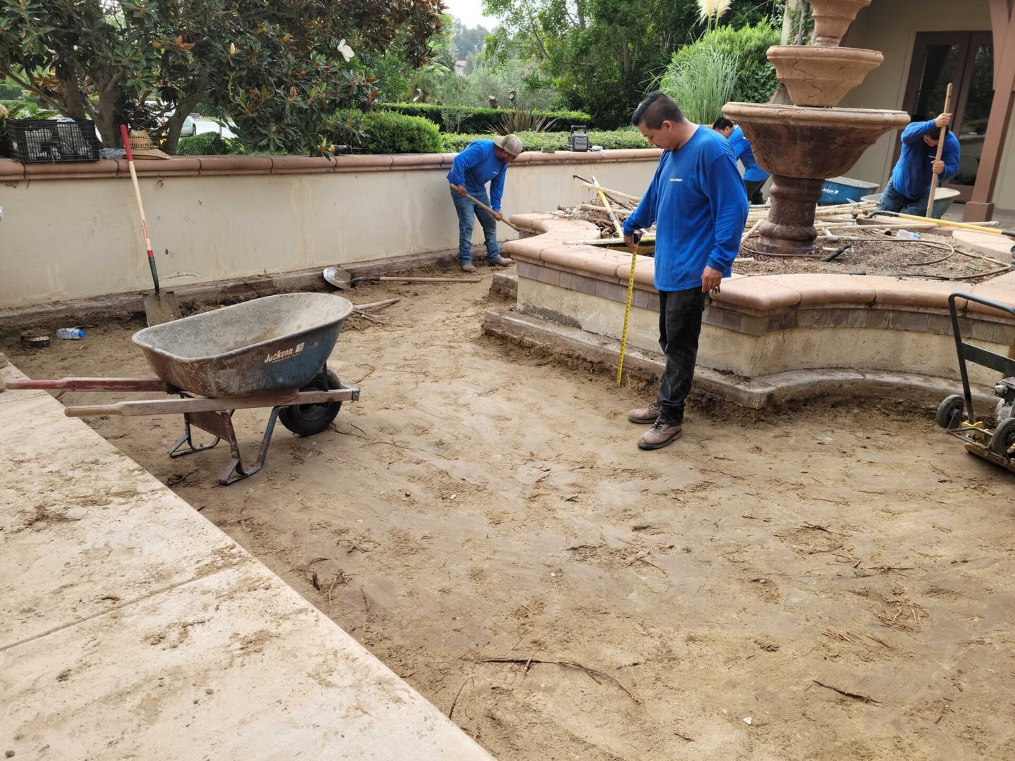 An Install-It-Direct crew checking grade during base prep on a San Diego backyard